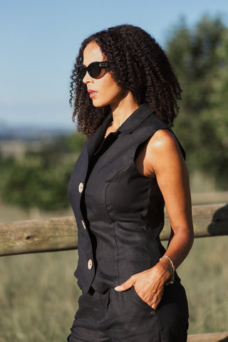 Woman wearing a black sleeveless linen blazer and sunglasses outdoors