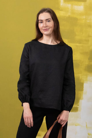 DE TIAMO Cleo Long Sleeve Top in black — front view showing flowing unstructured linen drape