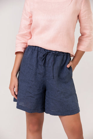 DE TIAMO Dani Linen Shorts in denim — close-up lifestyle detail styled with cerise pink linen top