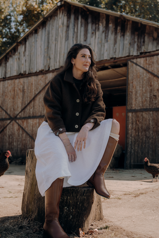 DE TIAMO Matilda Boiled Wool Jacket in chocolate — lifestyle shot, seated, showing relaxed winter styling